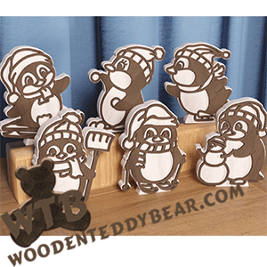Example of all six finished penguin stand-ups using maple with a walnut overlay on a wooden stand, featuring the brand 'WoodenTeddyBear.com'.